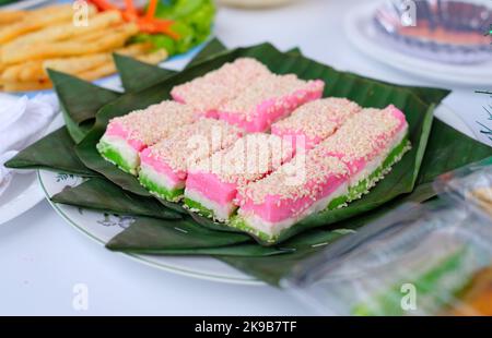 Rainbow Swirl Cake. Quadratischer Regenbogenkuchen auf Bananenblättern Stockfoto