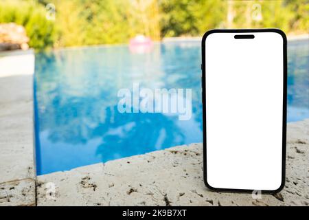 Vertikales Smartphone-Modell, weißer, leerer Bildschirm mit vertikalem Smartphone-Modell. Anwendungskonzept für Urlaub, Sommer, Urlaub, Schwimmbad. Stockfoto