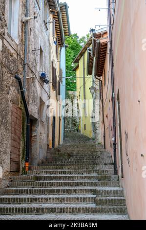 Eine typische Straßenszene in der Altstadt von Spoleto mit traditionellen Steinhäusern und engen Gassen, die am frühen Morgen fotografiert wurden. Umbrien, Italien. Stockfoto