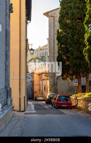 Blick auf die Via Gregorio Elladio und die Via Ponzianina, enge Gassen in der Altstadt von Spoleto mit alten Steinhäusern, die bei Sonnenaufgang aufgenommen wurden. Umbrien, Italien. Stockfoto