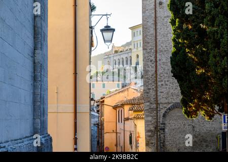 Blick auf die Via Gregorio Elladio und die Via Ponzianina, enge Gassen in der Altstadt von Spoleto mit alten Steinhäusern, die bei Sonnenaufgang aufgenommen wurden. Umbrien, Italien. Stockfoto