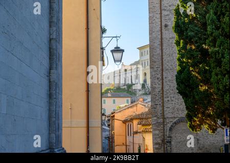 Blick auf die Via Gregorio Elladio und die Via Ponzianina, enge Gassen in der Altstadt von Spoleto mit alten Steinhäusern, die bei Sonnenaufgang aufgenommen wurden. Umbrien, Italien. Stockfoto