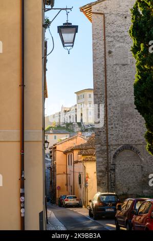 Blick auf die Via Gregorio Elladio und die Via Ponzianina, enge Gassen in der Altstadt von Spoleto mit alten Steinhäusern, die bei Sonnenaufgang aufgenommen wurden. Umbrien, Italien. Stockfoto