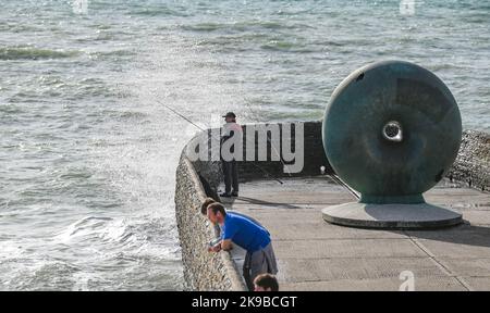 Brighton UK 27. October 2022 - Besucher und Fischer genießen einen heißen, sonnigen Tag am Strand und am Meer von Brighton, da die Temperaturen in einigen Teilen des Südostens voraussichtlich über 20 Grad erreichen werden. : Credit Simon Dack / Alamy Live News Stockfoto
