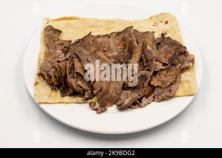 Türkischer Fleischspender isoliert auf weißem Hintergrund. Traditionelle Aromen. Döner Kebab aus Rind und Lamm. Nahaufnahme Stockfoto