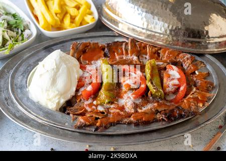 Türkischer iskender Kebab auf grauem Hintergrund. Traditionelle Aromen. Döner Kebab aus Rind und Lamm. Nahaufnahme Stockfoto