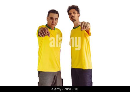 Black Brothers mit gelbem brasilianischem Hemd und Flaggenjubel isoliert auf Weiß. Fußballfans jubeln über den Sieg Brasiliens. Stockfoto