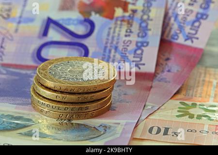 Clydesdale, Sterling Banknoten, mit zwei Pfund-Münzen mit der Aufschrift „auf den Schultern von Riesen stehen“. Münzen und Bargeld in harter Währung notieren Stockfoto