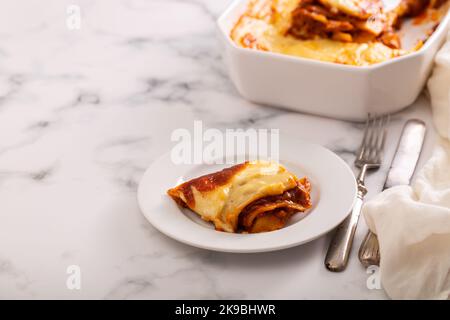 Frische Lasagne mit Fleisch- und Tomatensauce, die im Ofen in einer Keramikschale gebacken wurde. Stockfoto