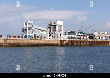 Eine angedockte Fähre von Irish Ferries gibt in der Ferne Rauch aus ihrem Schornstein frei, hinter einigen Gebäuden am Fährhafen 10/09/22 im Hafen von Calais Stockfoto