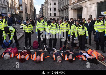 London, England, Großbritannien. 27. Oktober 2022. Klimaaktivisten von Just Stop Oil blockierten die Kreuzung von Queen Victoria Street und Cannon Street in der City of London. Die Aktivisten fordern, alle zukünftigen Lizenzen für die Erforschung und Entwicklung fossiler Brennstoffe in Großbritannien einzustellen. (Bild: © Thomas Krych/ZUMA Press Wire) Stockfoto