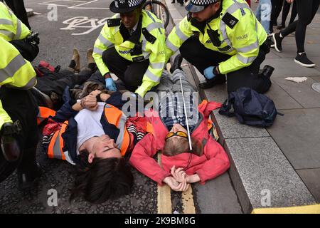 London, England, Großbritannien. 27. Oktober 2022. Klimaaktivisten von Just Stop Oil blockierten die Kreuzung von Queen Victoria Street und Cannon Street in der City of London. Die Aktivisten fordern, alle zukünftigen Lizenzen für die Erforschung und Entwicklung fossiler Brennstoffe in Großbritannien einzustellen. (Bild: © Thomas Krych/ZUMA Press Wire) Stockfoto