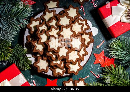 Weihnachtsstern Zucker glasierte Kekse, traditionelle Xmas dunkle und weiße Schokolade Lebkuchenkekse mit Feiertagsdekoration, Geschenke, Weihnachtsbaum-BH Stockfoto