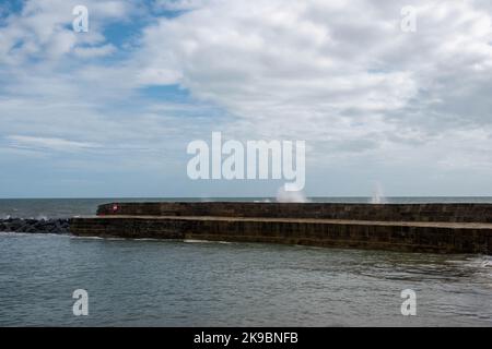 Wellen, die über dem weltberühmten Cobb bei Lyme Regis Dorset England schwammen, das in Jane Austens Roman Persuasion zu sehen ist Stockfoto