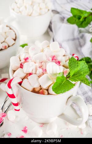 Hausgemachte Pfefferminze Heiße Schokolade. Zwei Tassen heißer Kakao, mit Minze, Marshmallow und Zuckerrohr, auf weißem Tischhintergrund Stockfoto