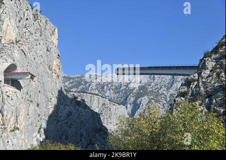 Das Projekt der Umgehungsstraße von Omis an der dalmatinischen Küste Kroatiens, das den Bau einer 216 Meter langen Brücke umfasst, die zwei Tunnel verbindet, ist in vollem Gange. Dies ist eines der komplexesten Infrastrukturprojekte, die derzeit in Kroatien durchgeführt werden, und wird auch den Bau der Schnellstraße Stobrec – Dugi Rat – Omis ermöglichen, die während der touristischen Saison dazu beitragen wird, Verkehrsprobleme auf der stark befahrenen Strecke Split-Omis zu lindern. Der Bau der Brücke 70 Meter über der Schlucht des Flusses Cetina, die den neuen Komorjak-Tunnel mit dem bestehenden Omis-Tunnel verbinden wird, begann im Jahr 2019. Konstruktio Stockfoto