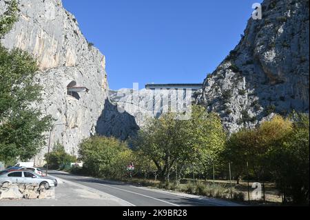 Das Projekt der Umgehungsstraße von Omis an der dalmatinischen Küste Kroatiens, das den Bau einer 216 Meter langen Brücke umfasst, die zwei Tunnel verbindet, ist in vollem Gange. Dies ist eines der komplexesten Infrastrukturprojekte, die derzeit in Kroatien durchgeführt werden, und wird auch den Bau der Schnellstraße Stobrec – Dugi Rat – Omis ermöglichen, die während der touristischen Saison dazu beitragen wird, Verkehrsprobleme auf der stark befahrenen Strecke Split-Omis zu lindern. Der Bau der Brücke 70 Meter über der Schlucht des Flusses Cetina, die den neuen Komorjak-Tunnel mit dem bestehenden Omis-Tunnel verbinden wird, begann im Jahr 2019. Konstruktio Stockfoto