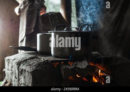 Nahaufnahme von zwei Eisentöpfen auf einem traditionellen kolumbianischen Herd. Herd mit Holz als Brennstoff beleuchtet. Traditionelle Küche auf einem Bauernhof in kolumbien. Konzept der Stockfoto