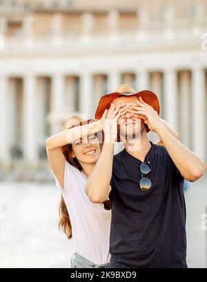 Porträt eines glücklichen jungen Paares, eine Frau macht eine Überraschung, schließt die Augen eines Mannes Stockfoto