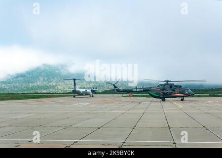 Yuzhno-Kurilsk, Russland - 03. August 2022: Hubschrauber und Flugzeug auf dem Flughafen der Insel Kunashir Vorbereitung für den Start Stockfoto