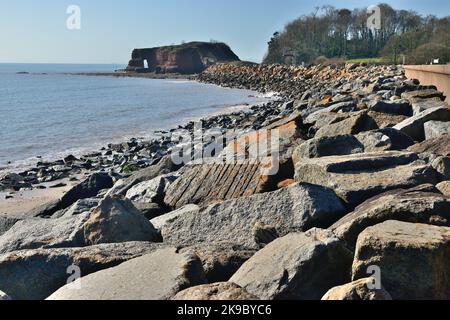 Felsrüstung entlang der Ufermauer bei Dawlish Warren, mit Blick auf Langstone Rock. Stockfoto