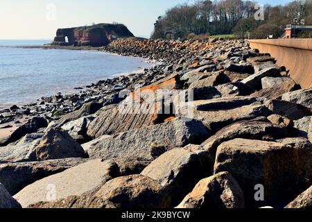 Felsrüstung entlang der Ufermauer bei Dawlish Warren, mit Blick auf Langstone Rock. Stockfoto