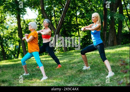 Gruppe von schönen sportlichen Senior Frauen Training im Freien - Ältere Erwachsene alte Freunde tun Fitness-Workout-Übungen in einem Park, um gesund zu bleiben und f Stockfoto