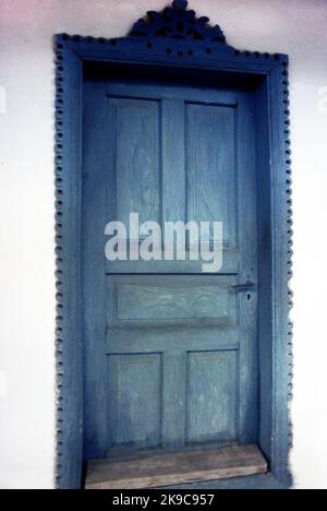 Kreis Gorj, Rumänien, ca. 2000. Einfache Holztür eines traditionellen alten Hauses, mit schönen handgeschnitzten Zierleisten. Stockfoto