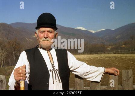 Kreis Gorj, Rumänien, ca. 2000. Älterer Mann mit Gehstock in traditioneller lokaler Kleidung. Stockfoto