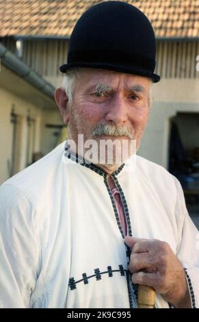 Kreis Gorj, Rumänien, ca. 2000. Älterer Mann mit Gehstock in traditioneller lokaler Kleidung. Stockfoto