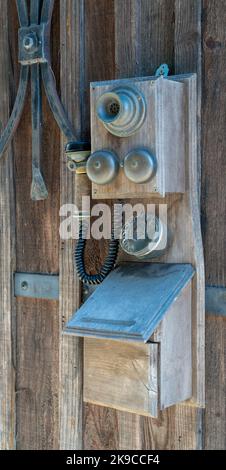 Ein französisches Vintage-Telefon mit separatem Horn und Lautsprecher ziert eine Holzwand Stockfoto