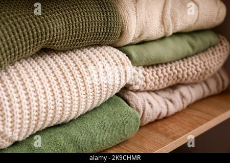 Gefaltete Pullover im Regal im Kleiderschrank, Nahaufnahme Stockfoto