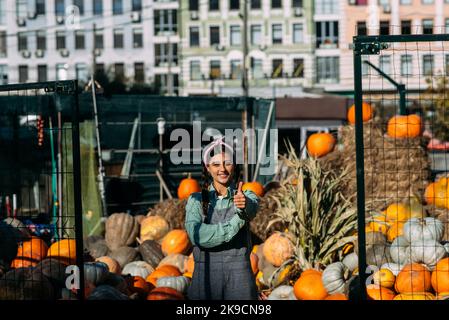Die Bäuerin verkauft auf dem Markt die Herbsternte der Kürbis Stockfoto