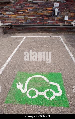 Alcantara, Spanien - 6.. Okt 2022: Tesla Ladestation für Elektroautos in ländlicher Umgebung. Wand aus natürlichem Rostschiefer. Alcantara Caceres, Spanien. Stockfoto