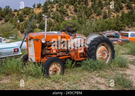 Ein alter rostiger, orangefarbener Oldtimer-Traktor, der in einem Schrottplatz im Bundesstaat Arizona, USA, geparkt wurde Stockfoto