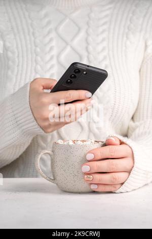 Weibliche Hand, die eine Tasse heißen Kakao Stockfoto