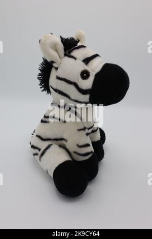 Niedliche schwarz-weiße Plüsch Zebra Figur, Kuscheltier auf weißem Hintergrund Stockfoto