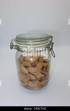 Glas gefüllt mit getrockneten, dehydrierten Apfelscheiben auf weißem Hintergrund Stockfoto