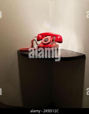 Ein rotes Telefon auf einem Tisch. Notruf. Stockfoto