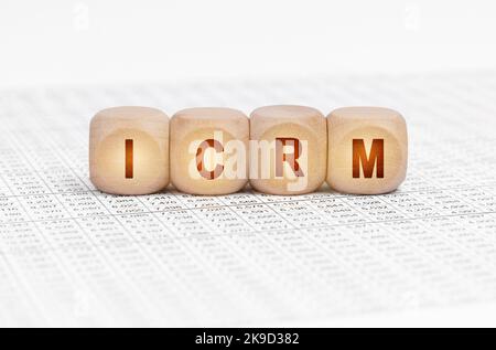 Geschäftskonzept. Auf dem Tisch mit Dokumenten befinden sich Holzwürfel mit der Aufschrift - ICRM Stockfoto
