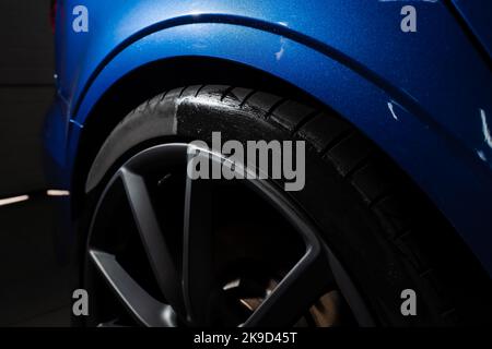 Schwärzung des Reifenrades des Autos mit Schwamm mit chemischer Schwärzung des Gummis in Detaillierung Auto-Service Stockfoto
