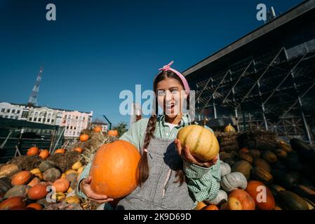 Eine junge Verkäuferin zeigt die Herbsternte Stockfoto