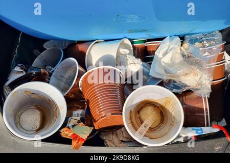 Abfalleimer voller weggeworfener gebrauchter Kaffeetassen und Kunststoffverpackungen, Abfallrecycling-Konzept Stockfoto