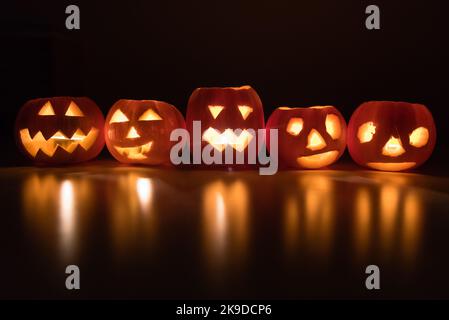 Olomouc, Tschechische Republik. 26. Oktober 2022. Halloween Kürbisse mit Kerzenlicht auf dem Tisch beleuchten einen dunklen Raum. Halloween wird am 31.. Oktober in vielen Ländern der Welt gefeiert. Zu den traditionellen Halloween-Aktivitäten gehören Trick or Treat, die Teilnahme an Halloween-Kostümpartys, Kürbisse schnitzen, gruselige Geschichten erzählen, Horror beobachten. (Foto von Tomas Tkacik/SOPA Images/Sipa USA) Quelle: SIPA USA/Alamy Live News Stockfoto