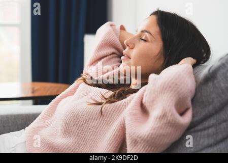Frau, die sich zu Hause entspannt. Junge Brünette Frau zu Hause in einer Freizeit denken Stockfoto