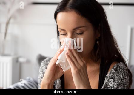 Kranke Frau, die ihre Nase bläst. Frau erkältet. Stockfoto