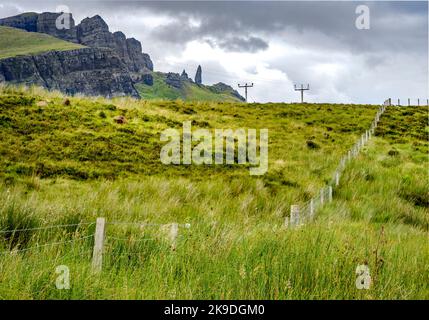 The Storr, jenseits in der Ferne, ein prominentes Skye Wahrzeichen, zerklüftete, schroffe Felswände, kleine Felseninsel, die aus dem Wasser ragt, Bergstraße neben dem Hotel Stockfoto