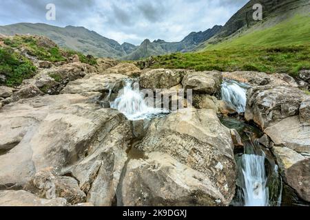 Lange Reihe von Wasserfällen und felsigen Bergpools am Fuße der Black Cuillin Mountains, beliebte Touristenattraktion, spektakuläre Skye-Landschaft, ein steiler Pfad Stockfoto