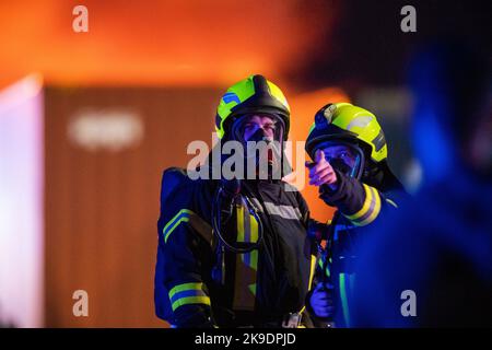 Bads Oeynhausen, Deutschland. 28. Oktober 2022. Feuerwehrleute sind auf dem Gelände eines Entsorgungsunternehmens zu sehen. (To dpa 'Gefahrguthalle in Bad Oeynhausen in Flammen') Quelle: Lino Mirgeler/dpa/Alamy Live News Stockfoto