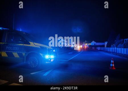 Bad Oeynhausen, Deutschland. 28. Oktober 2022. Eine Polizeistreife schließt die Straße vor dem Grundstück eines Entsorgungsunternehmens, wo die Halle für gefährliche Abfälle in Brand gesetzt wird. (To dpa 'gefährliche Abfallhalle in Bad Oeynhausen in Flammen') Quelle: Lino Mirgeler/dpa/Alamy Live News Stockfoto